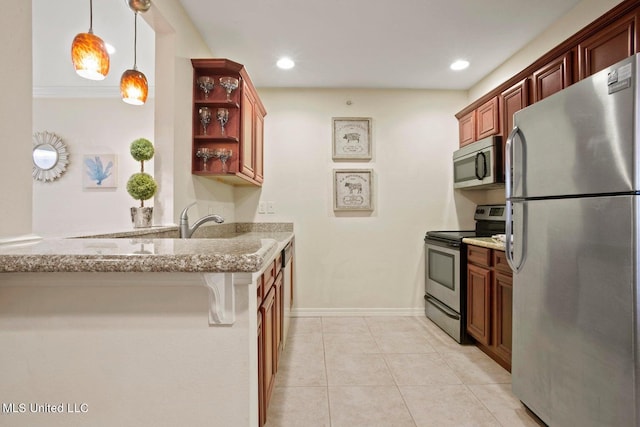 kitchen featuring kitchen peninsula, stainless steel appliances, a breakfast bar, light stone countertops, and decorative light fixtures