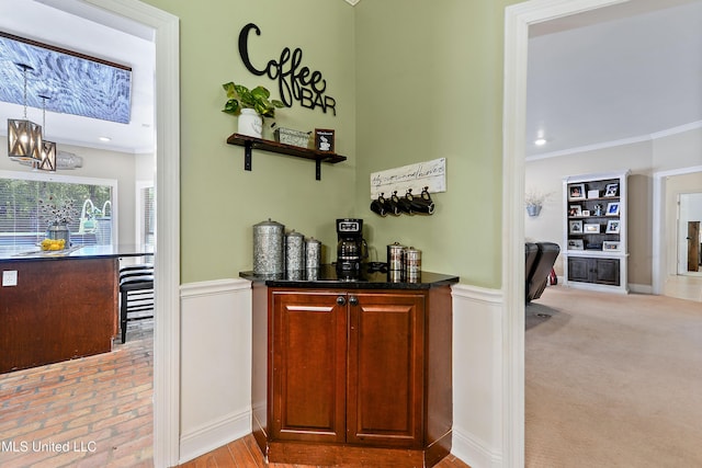 bar with wainscoting, decorative light fixtures, an inviting chandelier, and crown molding