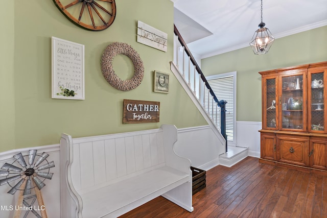 foyer featuring wood-type flooring, crown molding, stairway, and a wainscoted wall