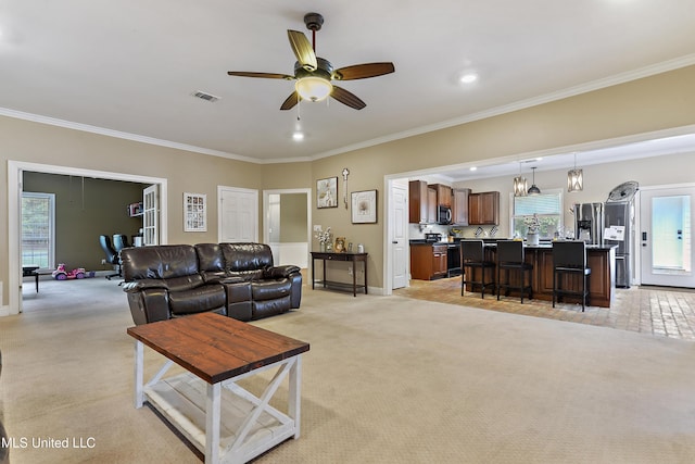 living area featuring ornamental molding, a ceiling fan, and visible vents