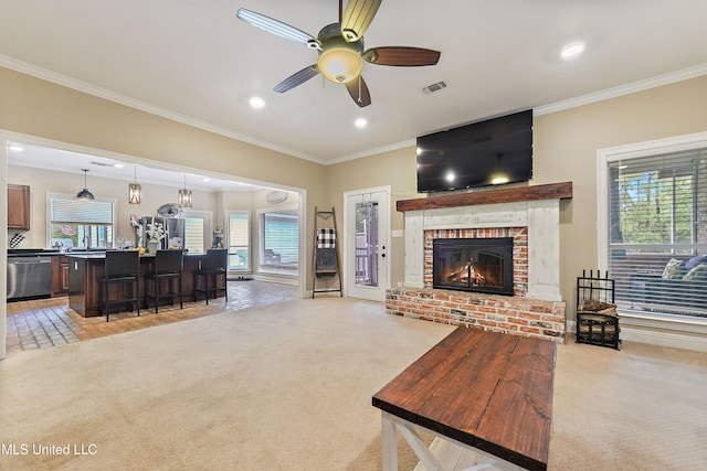 living area featuring ceiling fan, a brick fireplace, crown molding, and light carpet