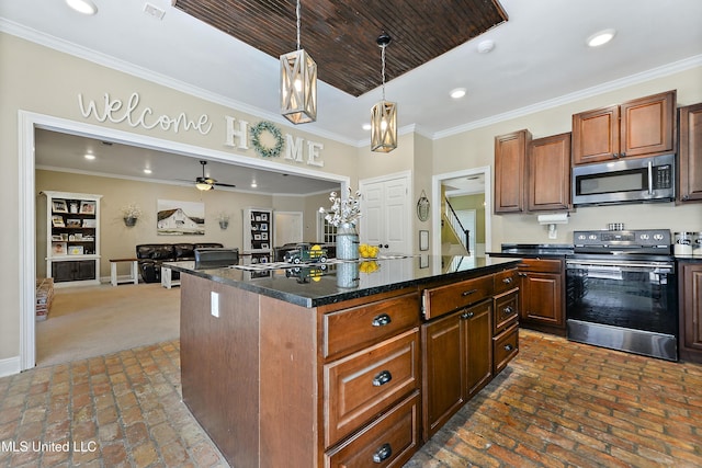 kitchen with stainless steel appliances, recessed lighting, pendant lighting, brick floor, and a kitchen island