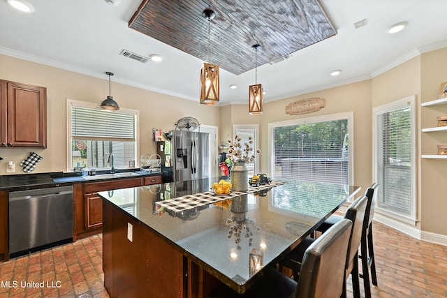 kitchen featuring a sink, brick floor, plenty of natural light, appliances with stainless steel finishes, and visible vents