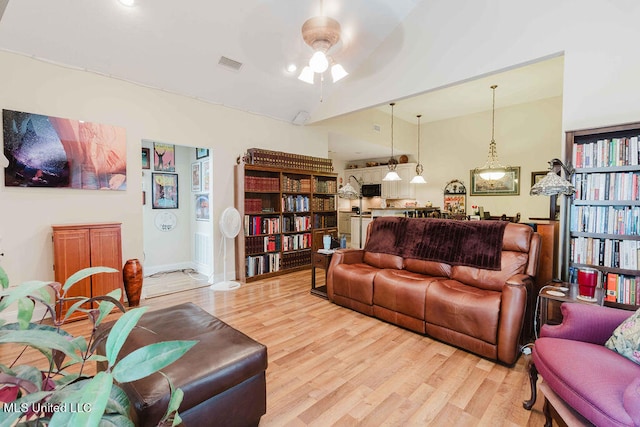 living room featuring high vaulted ceiling, light wood-type flooring, and ceiling fan