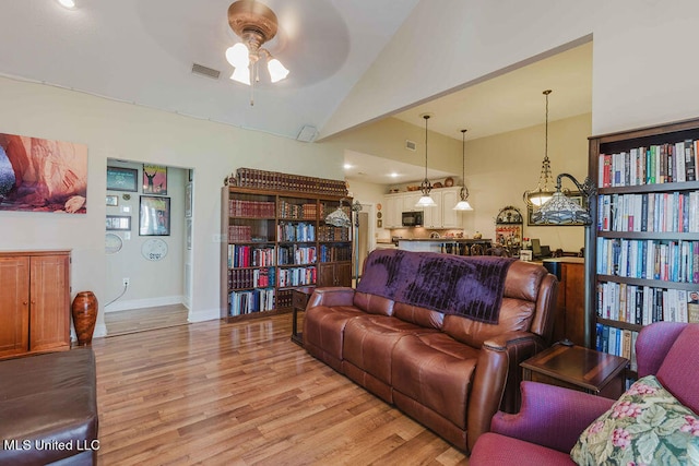 living room featuring ceiling fan, high vaulted ceiling, and light wood-type flooring