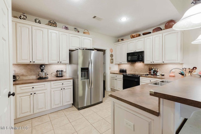 kitchen featuring white cabinets, black appliances, hanging light fixtures, and sink