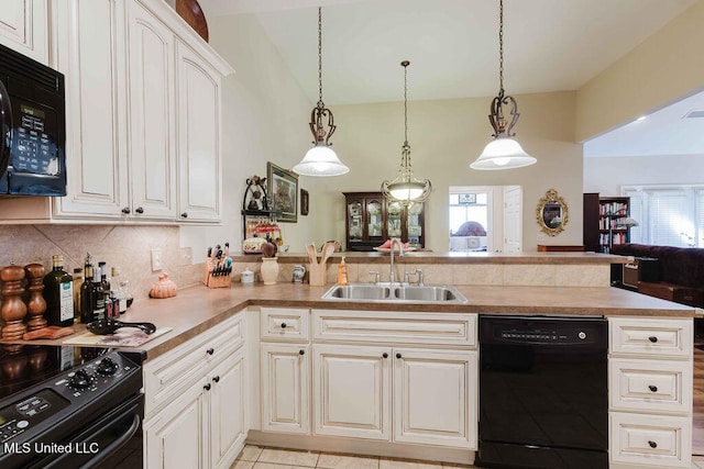 kitchen featuring vaulted ceiling, black appliances, a wealth of natural light, and pendant lighting