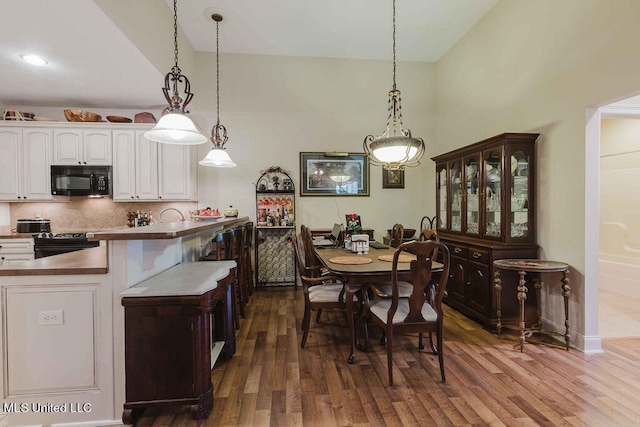 dining area featuring dark hardwood / wood-style floors and high vaulted ceiling