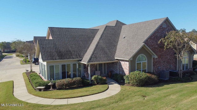 view of front of house featuring a front yard and central AC