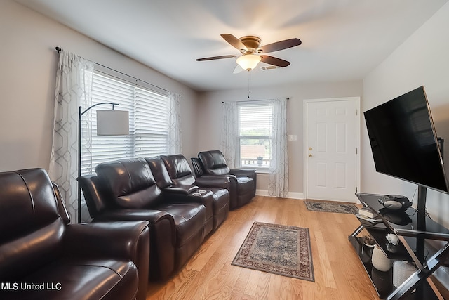 living room with light hardwood / wood-style flooring and ceiling fan