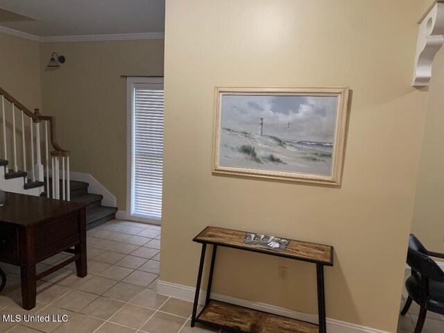 foyer entrance featuring light tile patterned floors, baseboards, ornamental molding, and stairs
