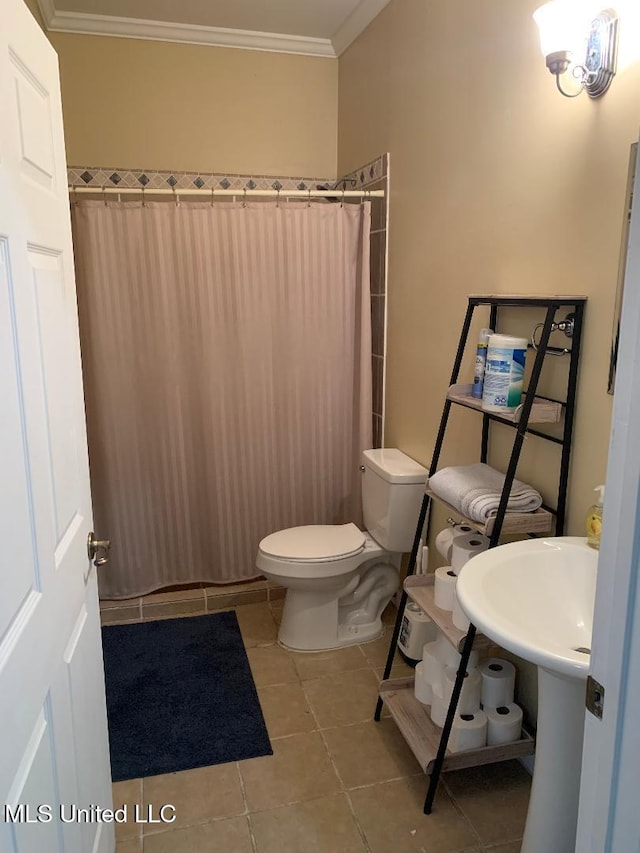 bathroom with toilet, crown molding, a shower with curtain, and tile patterned flooring