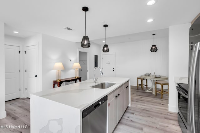 1302 Magnolia St Unit A101, Gulfport, MS 39507 - kitchen with stainless steel appliances, light wood finished floors, recessed lighting, decorative light fixtures, and a center island with sink