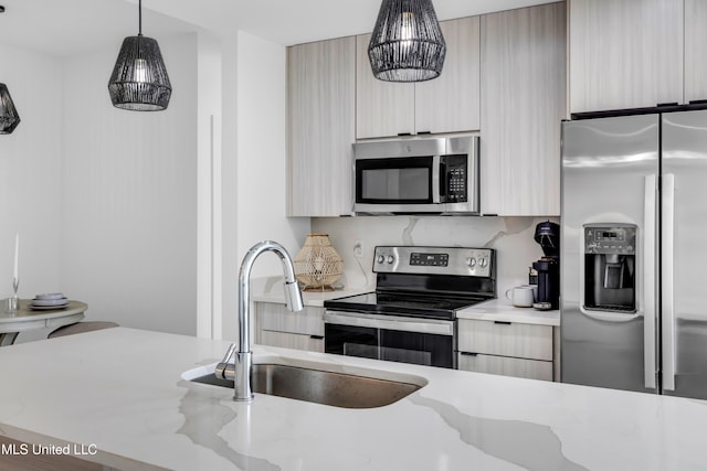 1302 Magnolia St Unit A101, Gulfport, MS 39507 - kitchen featuring stainless steel appliances, modern cabinets, pendant lighting, and light stone counters