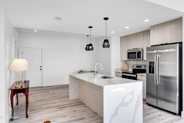 1302 Magnolia St Unit A101, Gulfport, MS 39507 - kitchen with stainless steel appliances, light wood-type flooring, modern cabinets, recessed lighting, and a kitchen island with sink