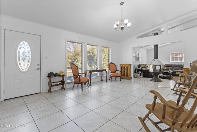 entrance foyer with a wood stove, a notable chandelier, lofted ceiling, and light tile patterned flooring