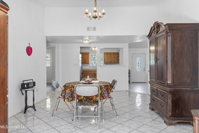 tiled dining space with a chandelier