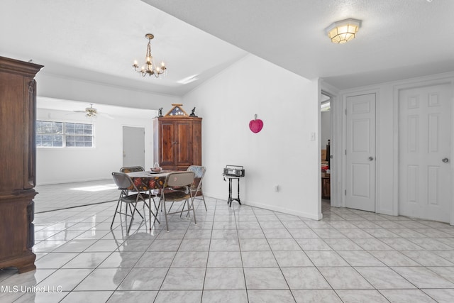 tiled dining area featuring vaulted ceiling, a textured ceiling, and ceiling fan with notable chandelier