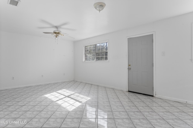 empty room with ceiling fan and light tile patterned floors