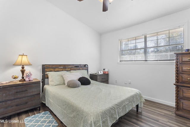 bedroom with dark hardwood / wood-style flooring, vaulted ceiling, and ceiling fan