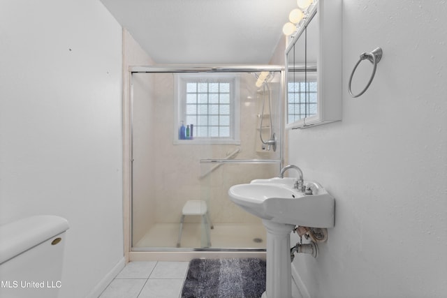 bathroom with tile patterned floors, toilet, and walk in shower