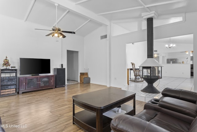 living room with ceiling fan with notable chandelier, beam ceiling, light wood-type flooring, and high vaulted ceiling