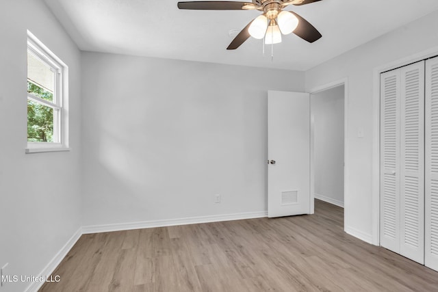 unfurnished bedroom featuring visible vents, a closet, baseboards, ceiling fan, and light wood-type flooring