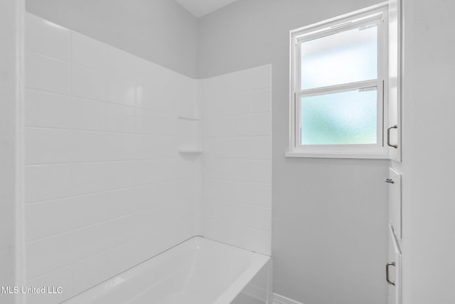 bathroom with baseboards and shower / bathtub combination
