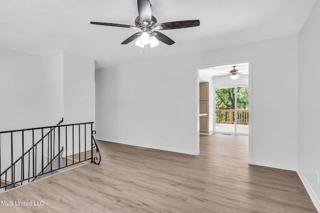 empty room with baseboards, ceiling fan, and wood finished floors