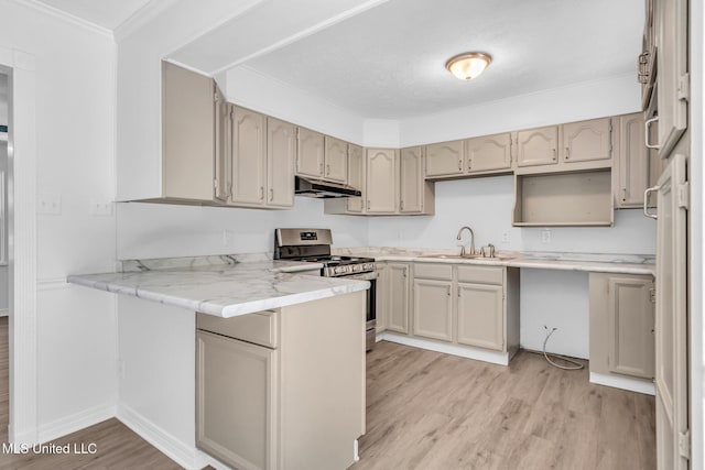 kitchen with stainless steel gas range oven, a sink, a peninsula, under cabinet range hood, and light wood-style flooring