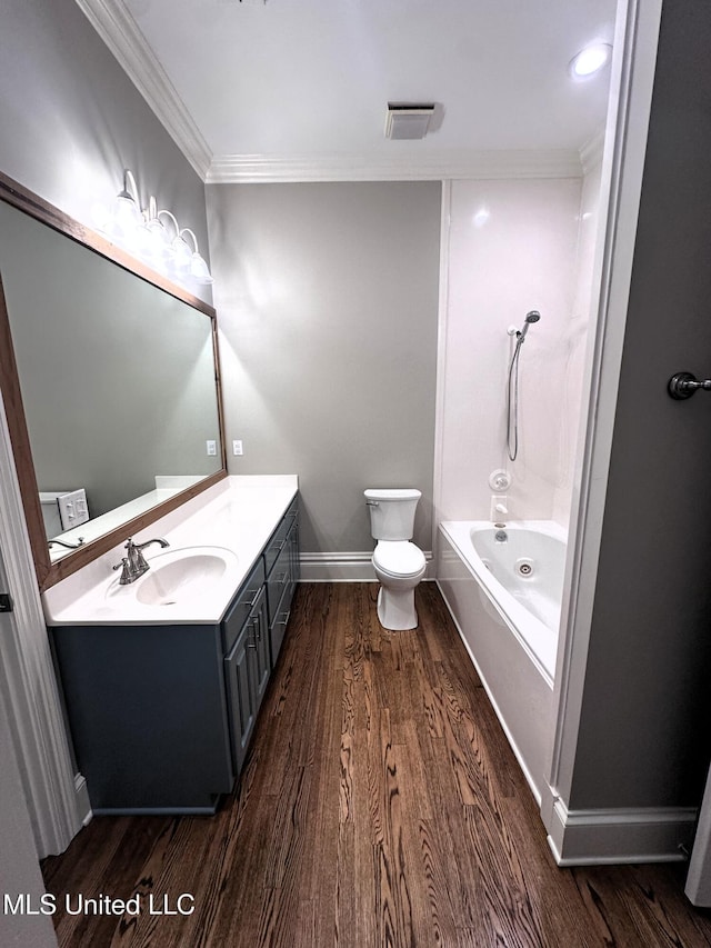 bathroom featuring vanity, wood finished floors, crown molding, and toilet