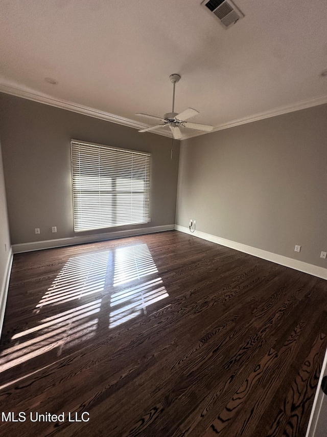 empty room with dark wood-style floors, visible vents, baseboards, and ornamental molding