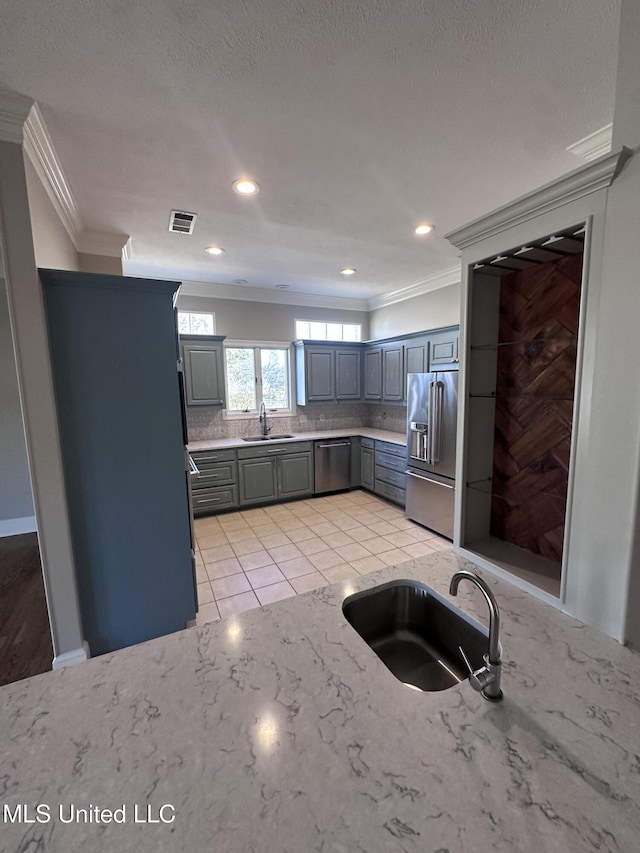 kitchen featuring gray cabinets, visible vents, appliances with stainless steel finishes, and a sink