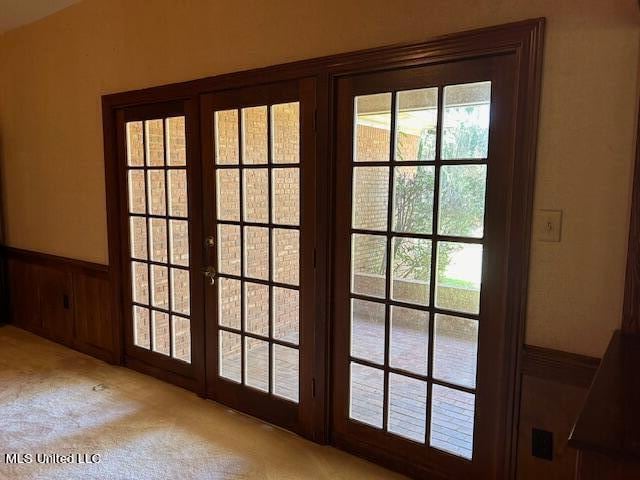 entryway with french doors and light carpet