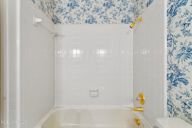 bathroom featuring toilet and tiled shower / bath combo