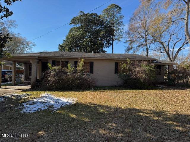 view of property exterior with an attached carport, concrete driveway, and a yard