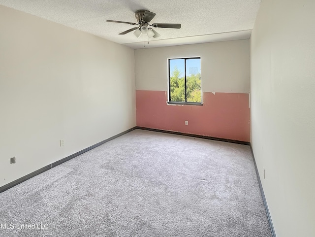 carpeted spare room with ceiling fan and a textured ceiling