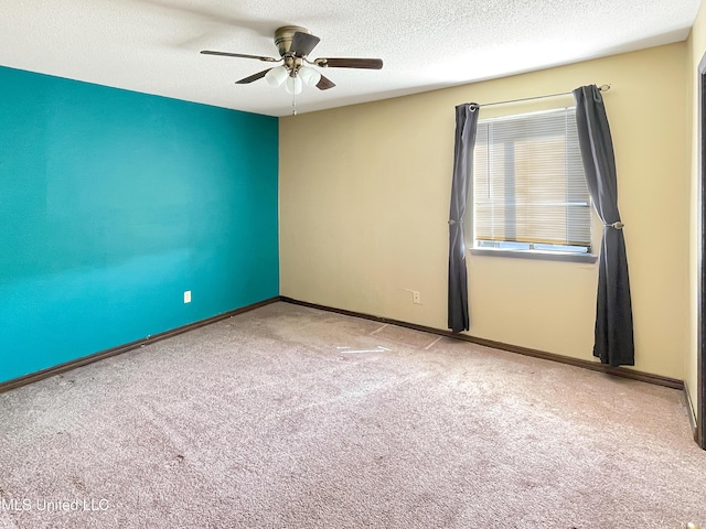 unfurnished room with carpet flooring, ceiling fan, and a textured ceiling