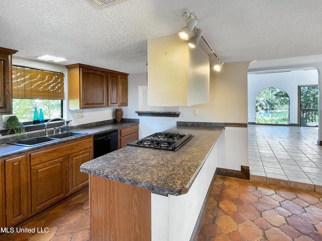 kitchen featuring dishwasher, a textured ceiling, stainless steel gas cooktop, and sink