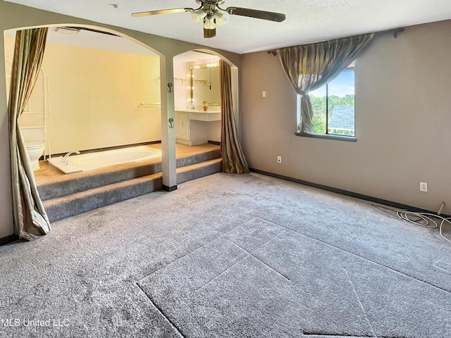 unfurnished bedroom with ceiling fan, carpet floors, and a textured ceiling