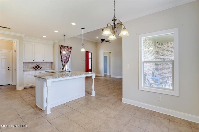 218 Greenfield Ridge Dr, Brandon, MS 39042 - kitchen featuring a chandelier, plenty of natural light, crown molding, light stone countertops, and decorative backsplash