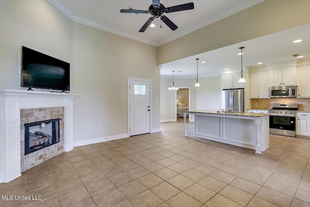 218 Greenfield Ridge Dr, Brandon, MS 39042 - kitchen featuring stainless steel appliances, open floor plan, ceiling fan, light tile patterned floors, and crown molding
