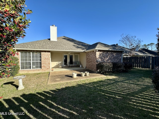 back of house featuring a patio area and a lawn