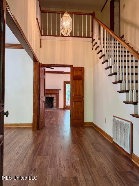 618 Gordon Pl Unit 618, Madison, MS 39110 - unfurnished living room with a towering ceiling, wood finished floors, a fireplace, a chandelier, and baseboards