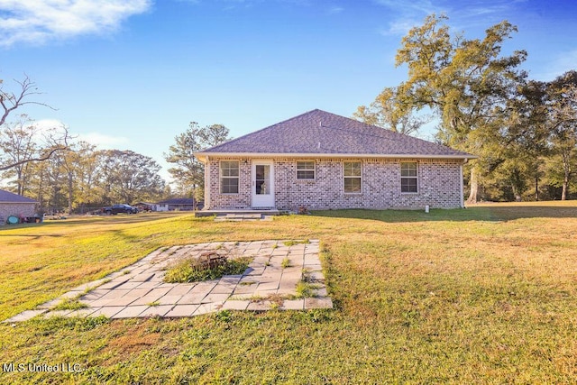 rear view of house featuring a lawn, a patio area, and a fire pit