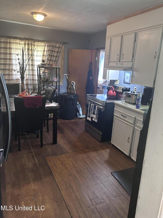 117 Shadow Lawn Dr, Jackson, MS 39204 - kitchen featuring dark wood-style flooring, electric range, under cabinet range hood, white cabinets, and a textured ceiling