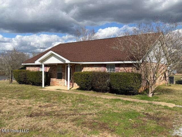 ranch-style home with brick siding and a front yard