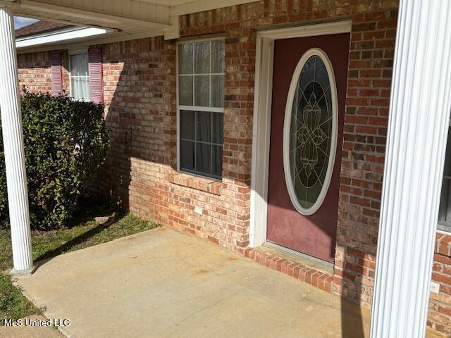 doorway to property featuring brick siding