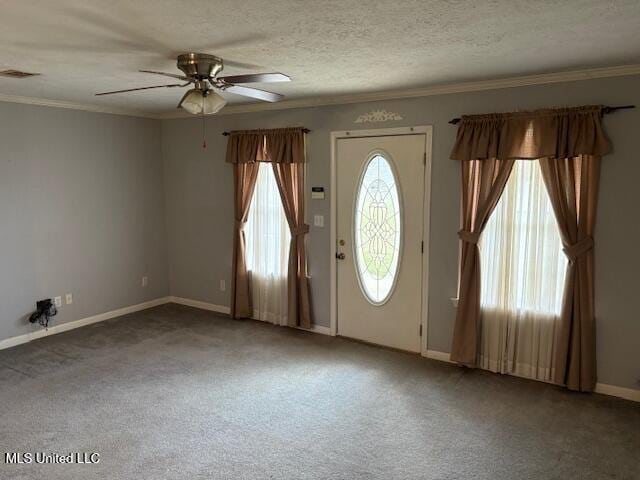 carpeted foyer entrance with visible vents, baseboards, a textured ceiling, and crown molding