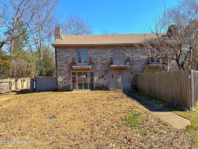 540 Woodland Hills Pl, Jackson, MS 39216 - back of house featuring brick siding, a chimney, and fence
